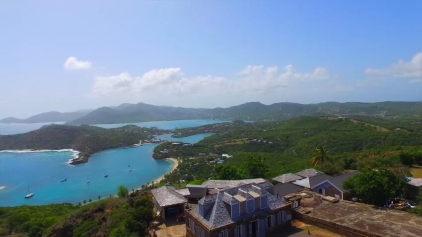 Hilltop view of Antigua’s turquoise bays, green coastline, and boats near the shore