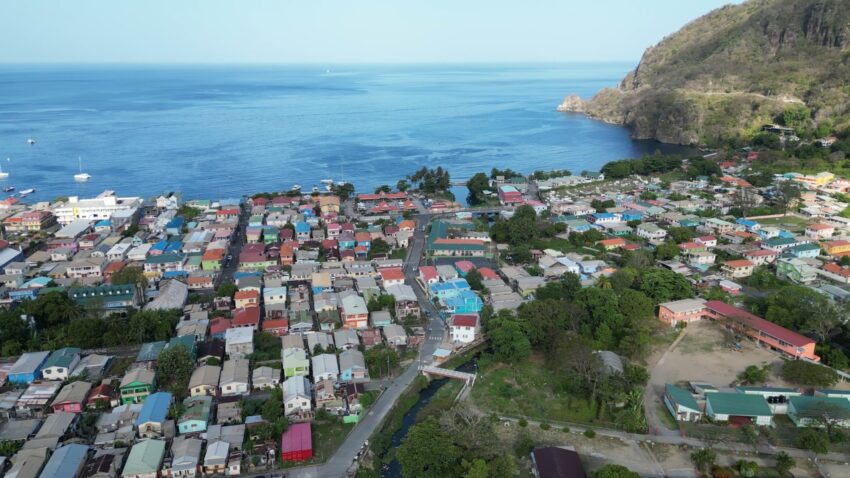 Aerial view of a coastal town in St. Lucia beside a blue bay