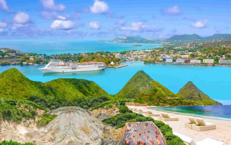 Panoramic view of the coast of Saint Lucia with turquoise sea, beach, green hills and cruise ship in the harbor