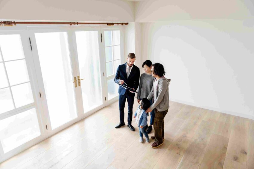 Real estate agent shows documents to family during tour of empty house