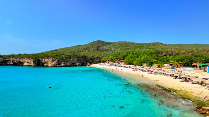 Turquoise water and a sandy Banda Abou beach with sunbeds along the Curaçao coast