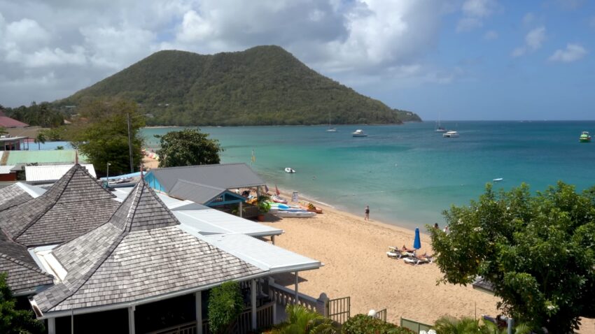 Beach and turquoise water near hillside homes in St. Lucia