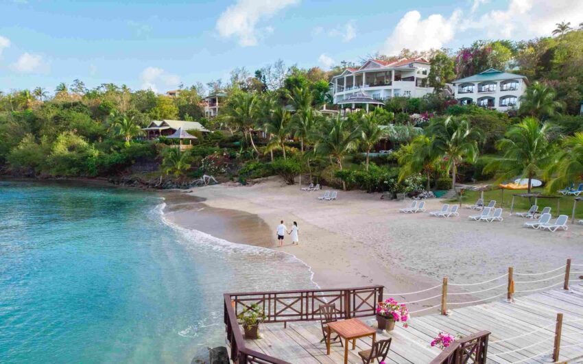 Tropical beachfront community with luxury homes, palm trees, and a sandy shoreline in St. Lucia