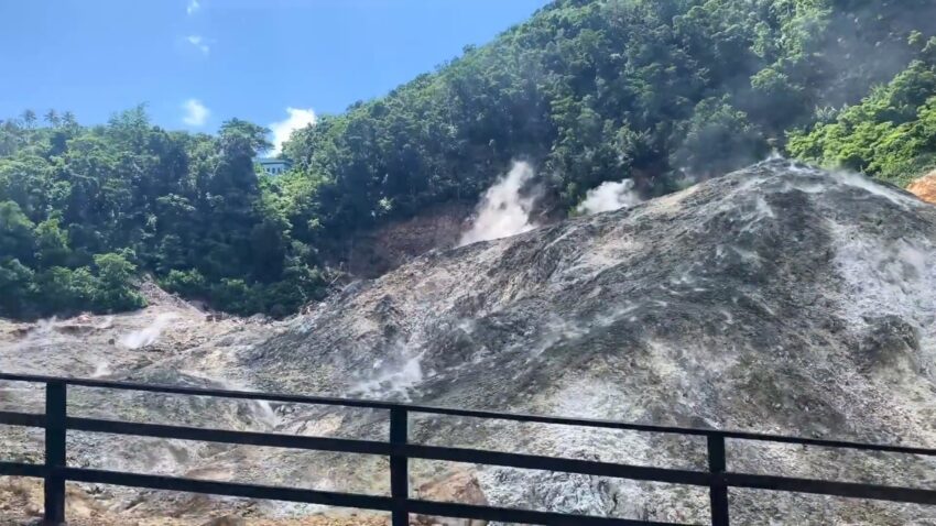 Steam rises across the rocky geothermal slopes at Sulphur Springs in St. Lucia